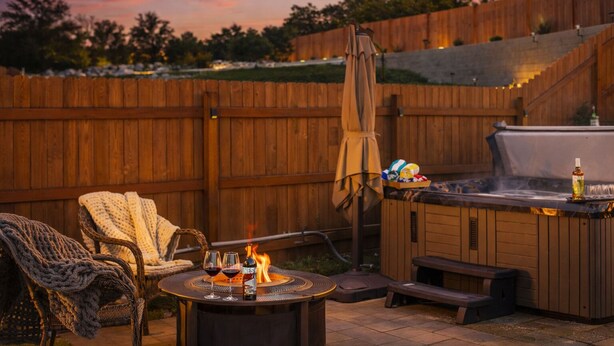 A backyard with a wooden deck, outdoor seating, a hot tub, and a fire pit. - Private hot tub / Close to town / Cozy and pet friendly (Chelan)
