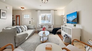 A modern living room with a sofa, a coffee table, and a TV. - Private hot tub / Close to town / Cozy and pet friendly (Chelan)