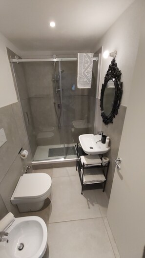 Une salle de bain moderne équipée d’une douche, de toilettes et d’un lavabo.