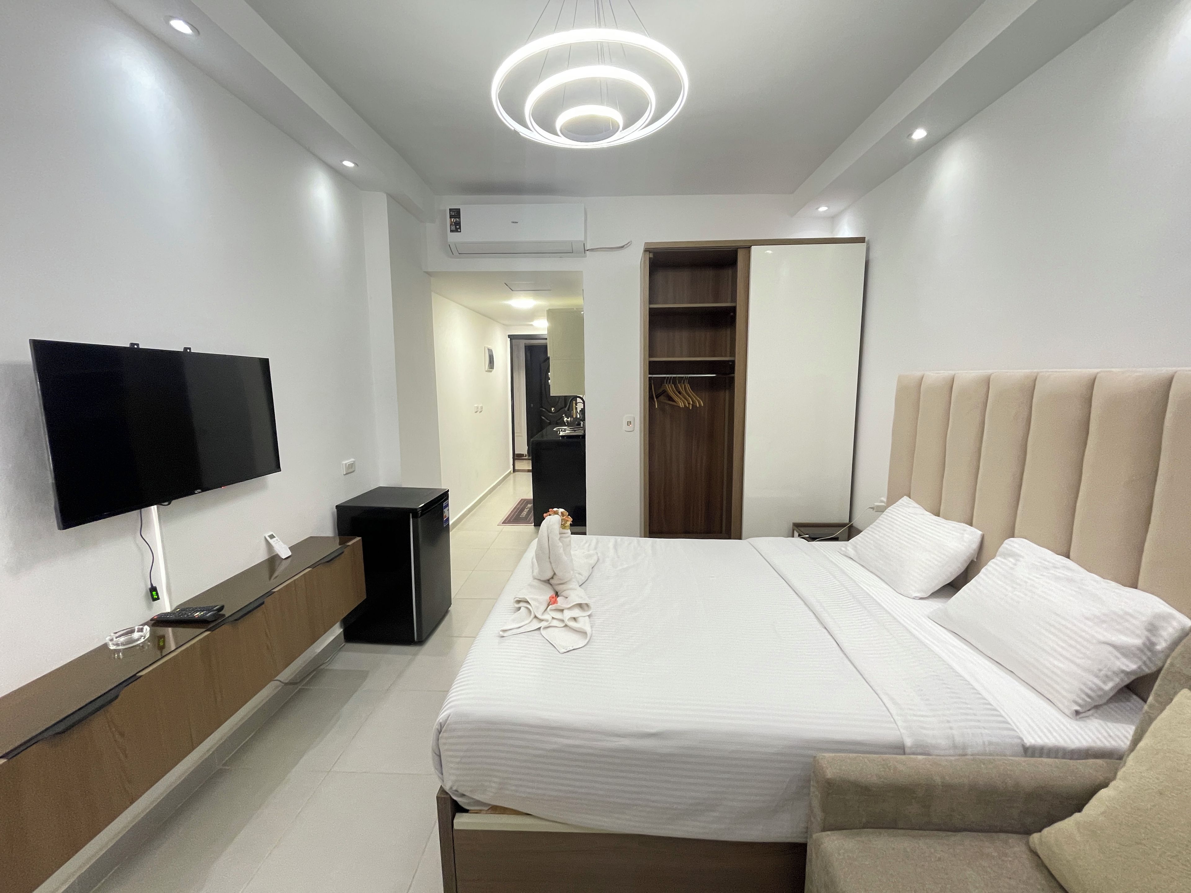 Une chambre d’hôtel équipée d’un lit, d’une télévision, d’un bureau, d’une armoire et d’un miroir.