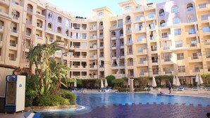 A hotel with multiple balconies, a swimming pool, and outdoor seating areas. - Florenza Khamsin Resort (Hurghada)