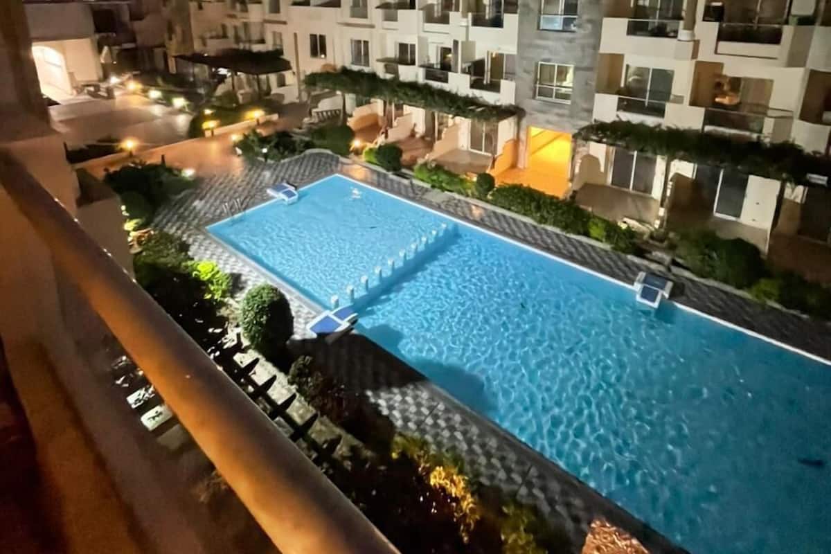 A residential building with multiple balconies and a swimming pool.