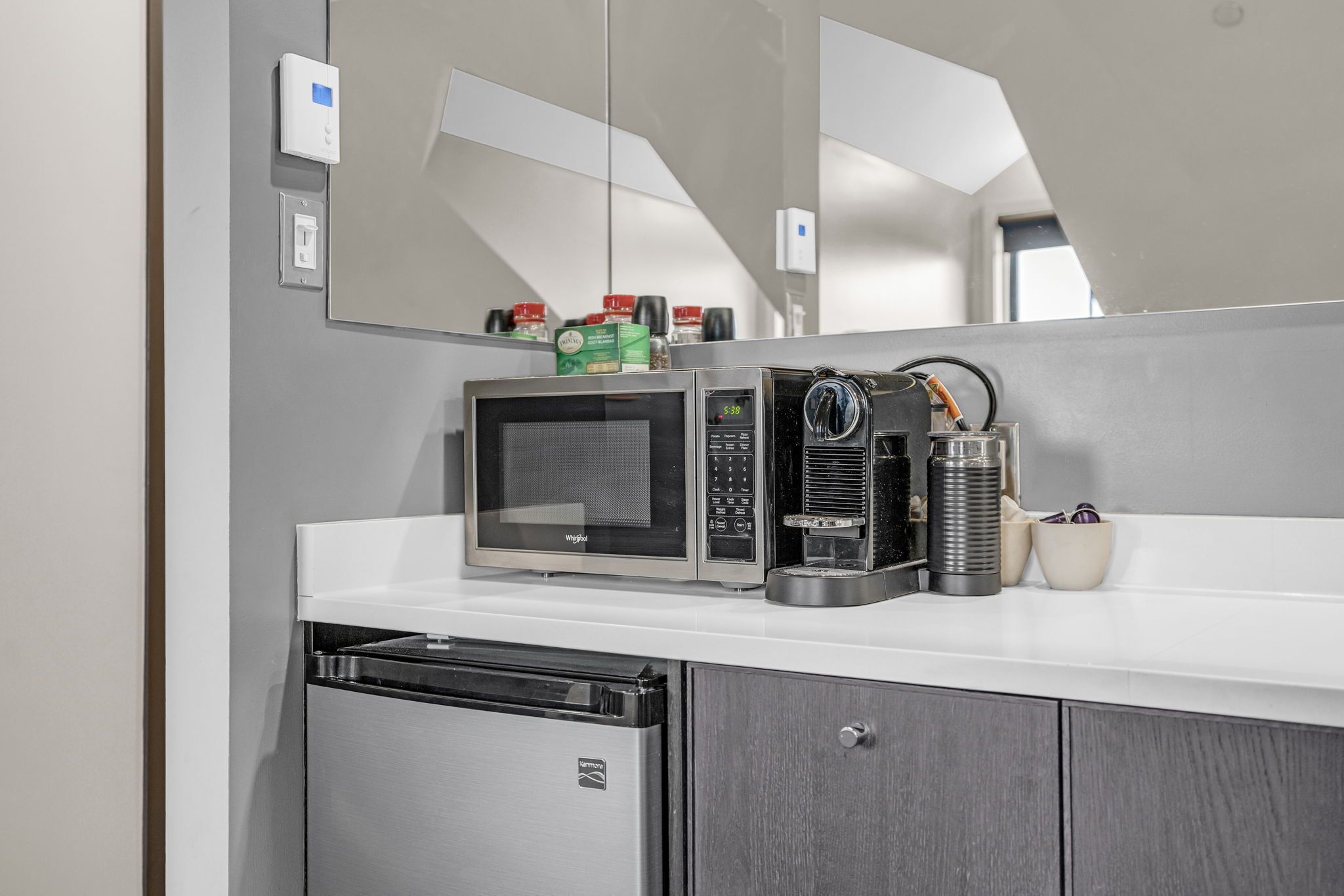 A compact kitchen with a microwave, coffee maker, and dishwasher.