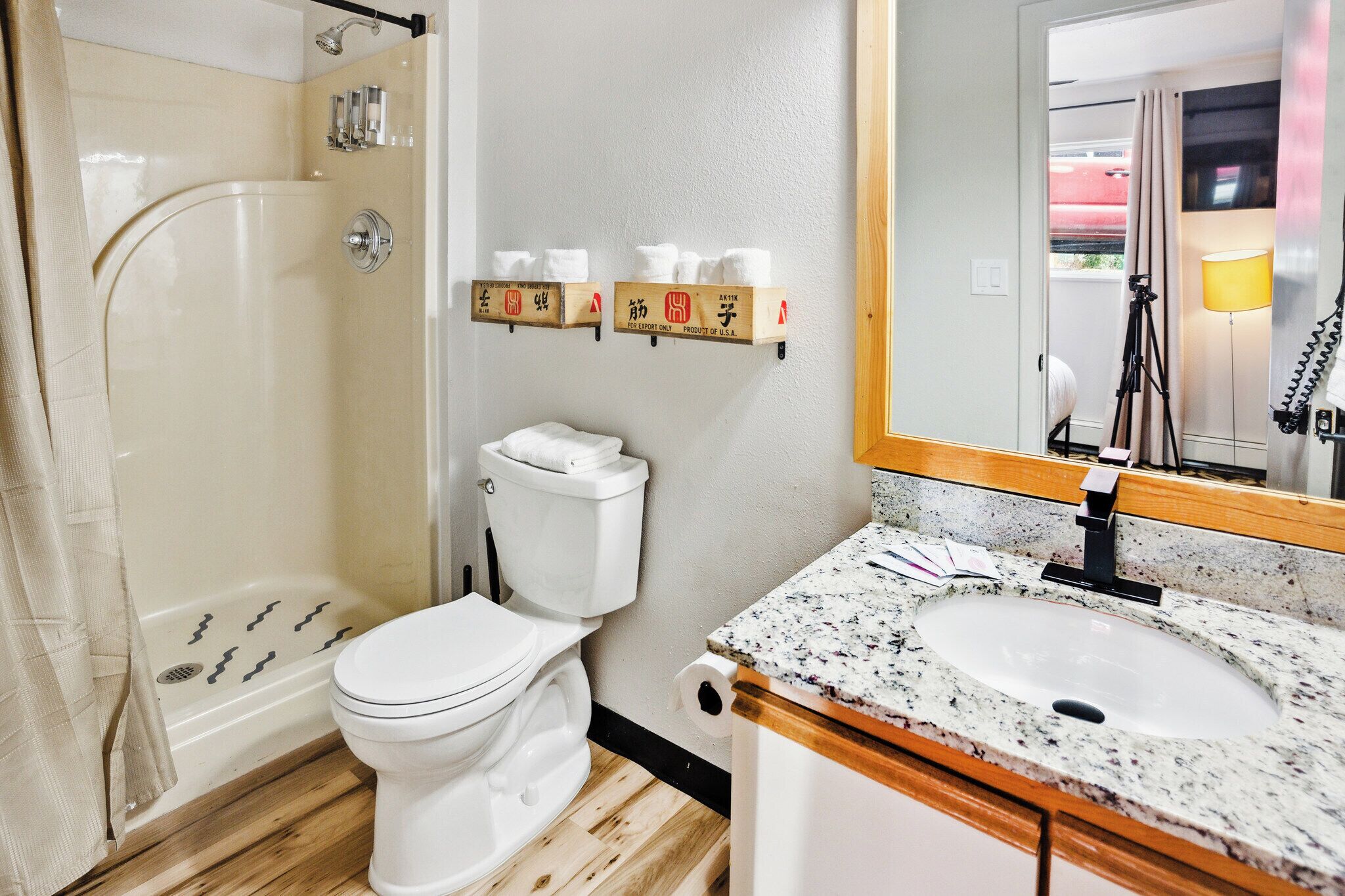 A bathroom with a shower, toilet, sink, and towel rack.