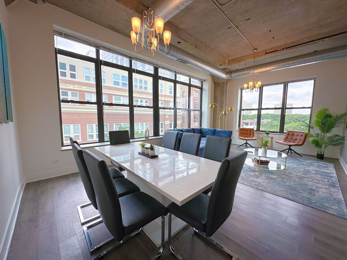 Une salle de réunion moderne, dotée d’une grande table, de sièges confortables et de larges fenêtres offrant une vue sur la ville.