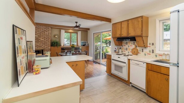 Una cucina moderna con mobili in legno, un'isola centrale e vista sull'esterno.