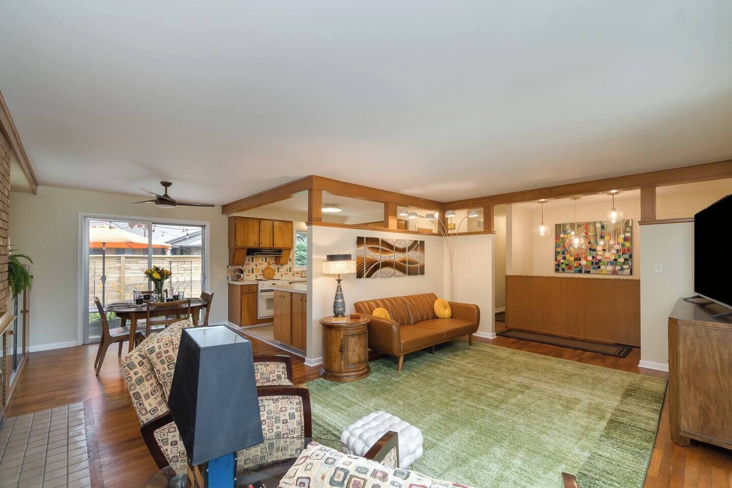 A spacious living area with a dining table, sofa, and TV.