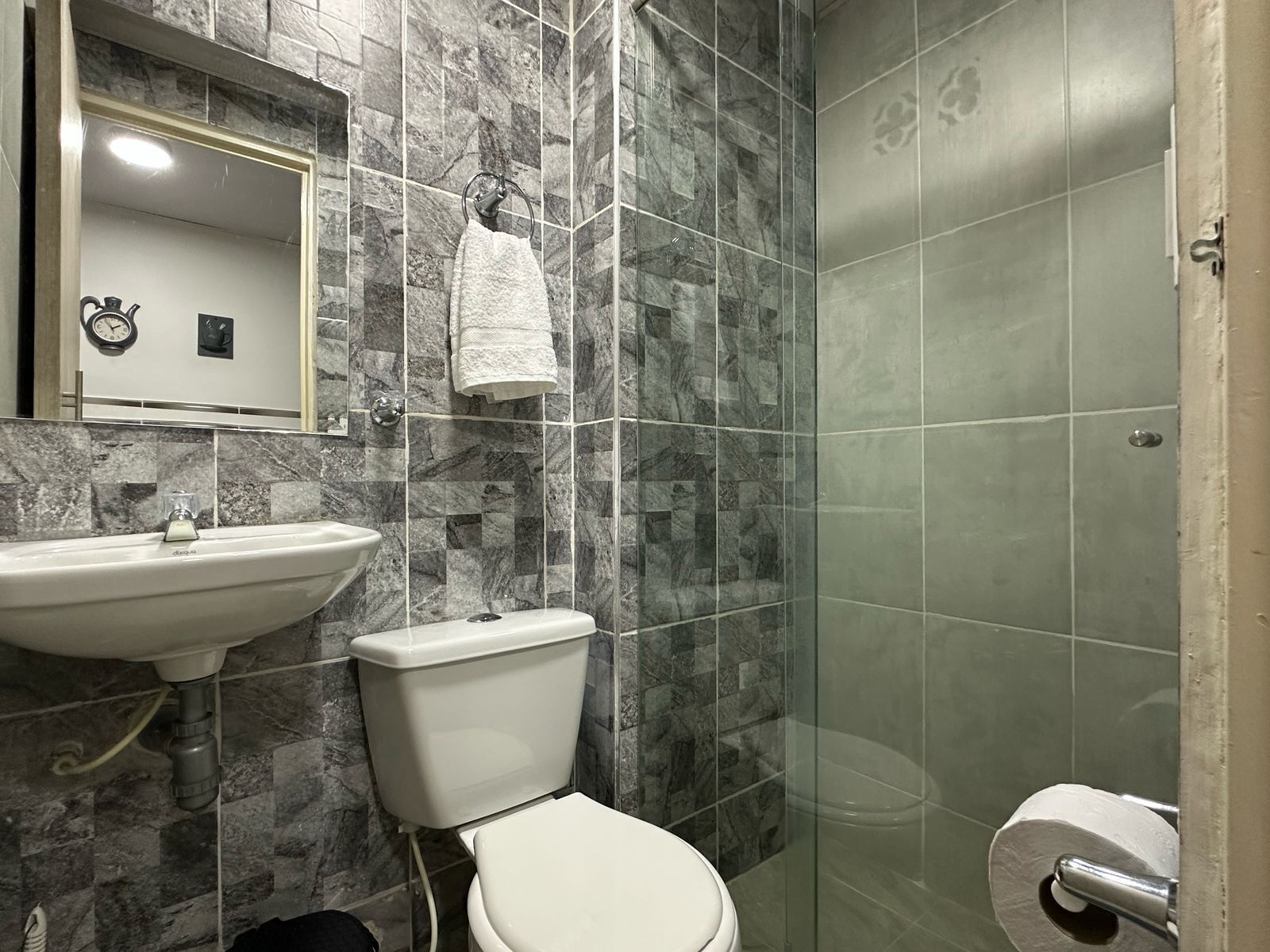 A bathroom with a sink, toilet, and shower.