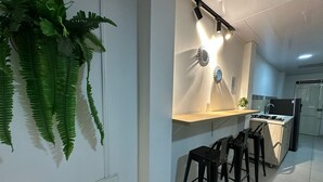 Μια μοντέρνα κουζίνα με κεντρικό πάγκο, σκαμπό μπαρ και κρεμαστά φωτιστικά.