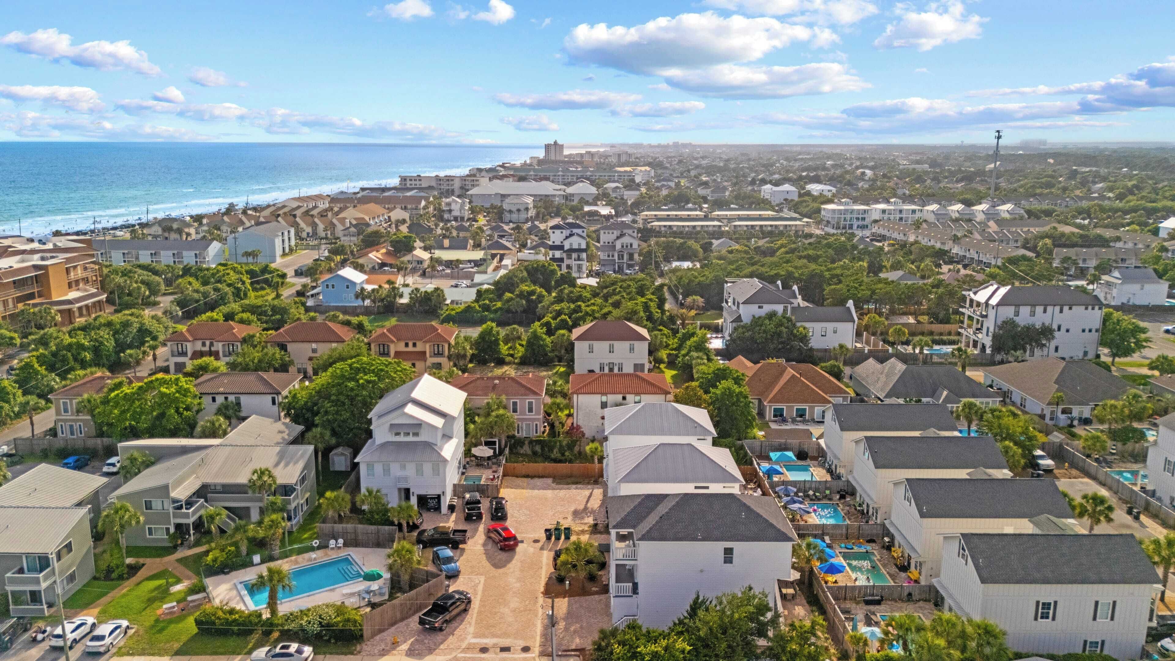 A residential area with houses, a swimming pool, and a view of the ocean.
