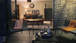 A cozy living room with a sofa, chairs, and a coffee table with drinks and glasses. - Walnut Farm, Kingscote, Cotswolds - Unique farm stay (Kingscote)