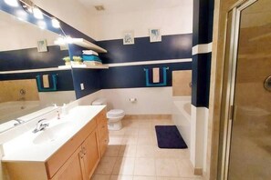 A modern bathroom with a large mirror, white sink, wooden cabinets, a toilet, and a shower area. - Stylish & Convenient 2Bd/1Bth~for Friends/Business/Family~FREE Parking (Atlanta)