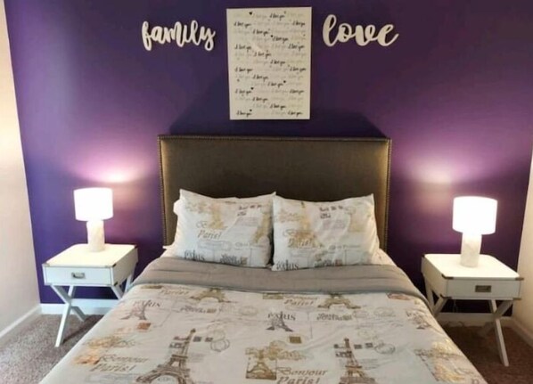A bedroom with a bed, two bedside tables, and a wall with 'family' and 'love' decor. - Stylish & Convenient 2Bd/1Bth~for Friends/Business/Family~FREE Parking (Atlanta)