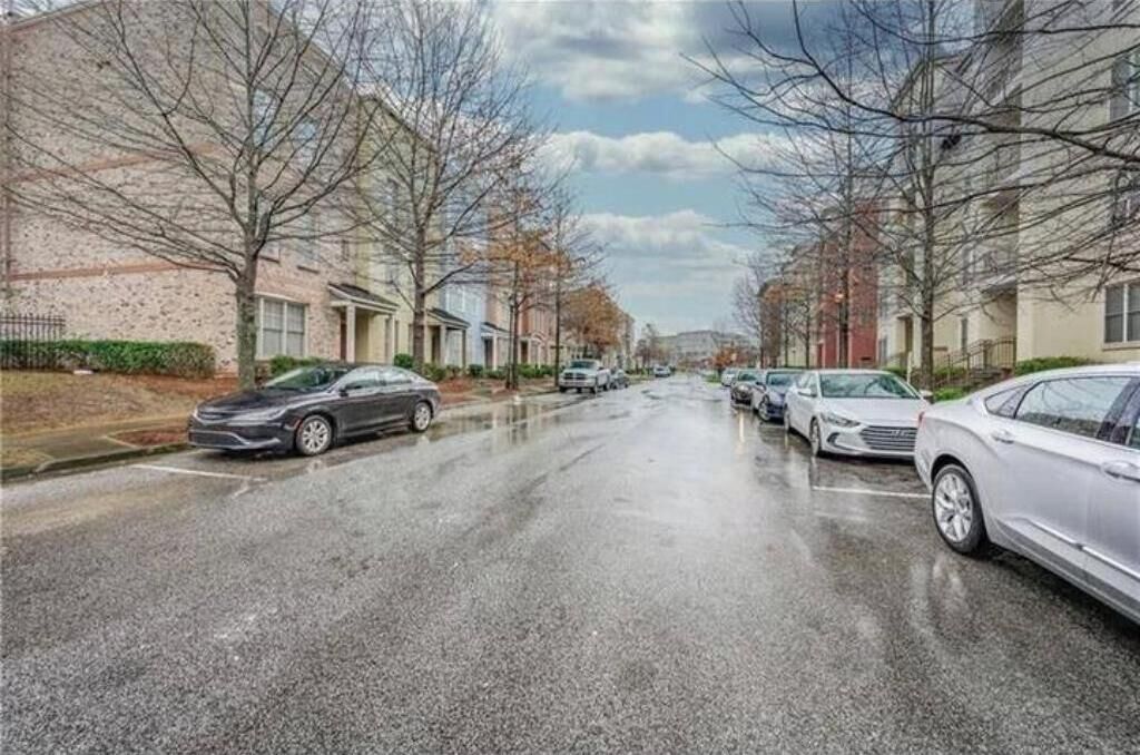 Eine Wohnstraße mit parkenden Autos und Häusern an beiden Seiten.