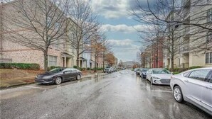 Una strada residenziale fiancheggiata da auto parcheggiate e case.