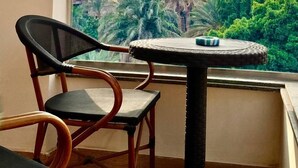 Un balcon avec vue sur les pyramides, une table ronde et deux chaises.