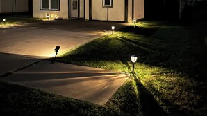 Un edifici residencial amb una entrada, un jardí i un fanal.