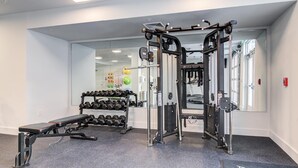 A gym with a bench, dumbbells, and a squat rack. - Landing | Incredible 1BD, Clubhouse, Pool (Decatur)