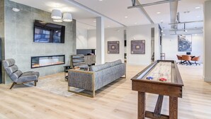 A spacious living area with a fireplace, a pool table, and a comfortable seating arrangement. - Landing | Incredible 1BD, Clubhouse, Pool (Decatur)