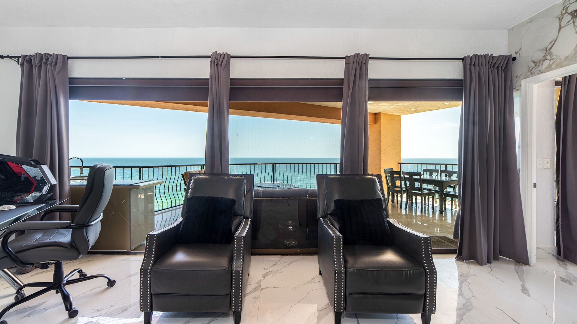 Habitación con vista al mar, que incluye un escritorio, dos sillas y un comedor.