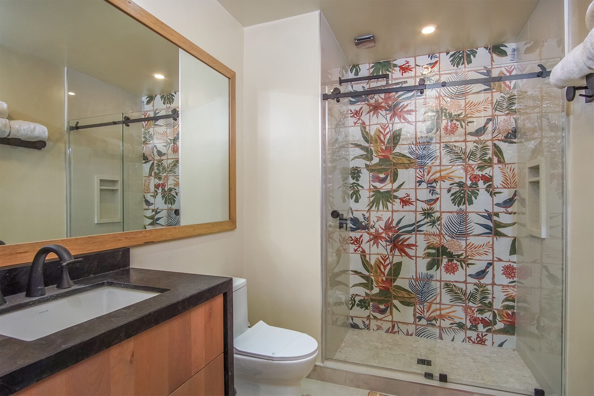 A bathroom with a shower, toilet, and sink.