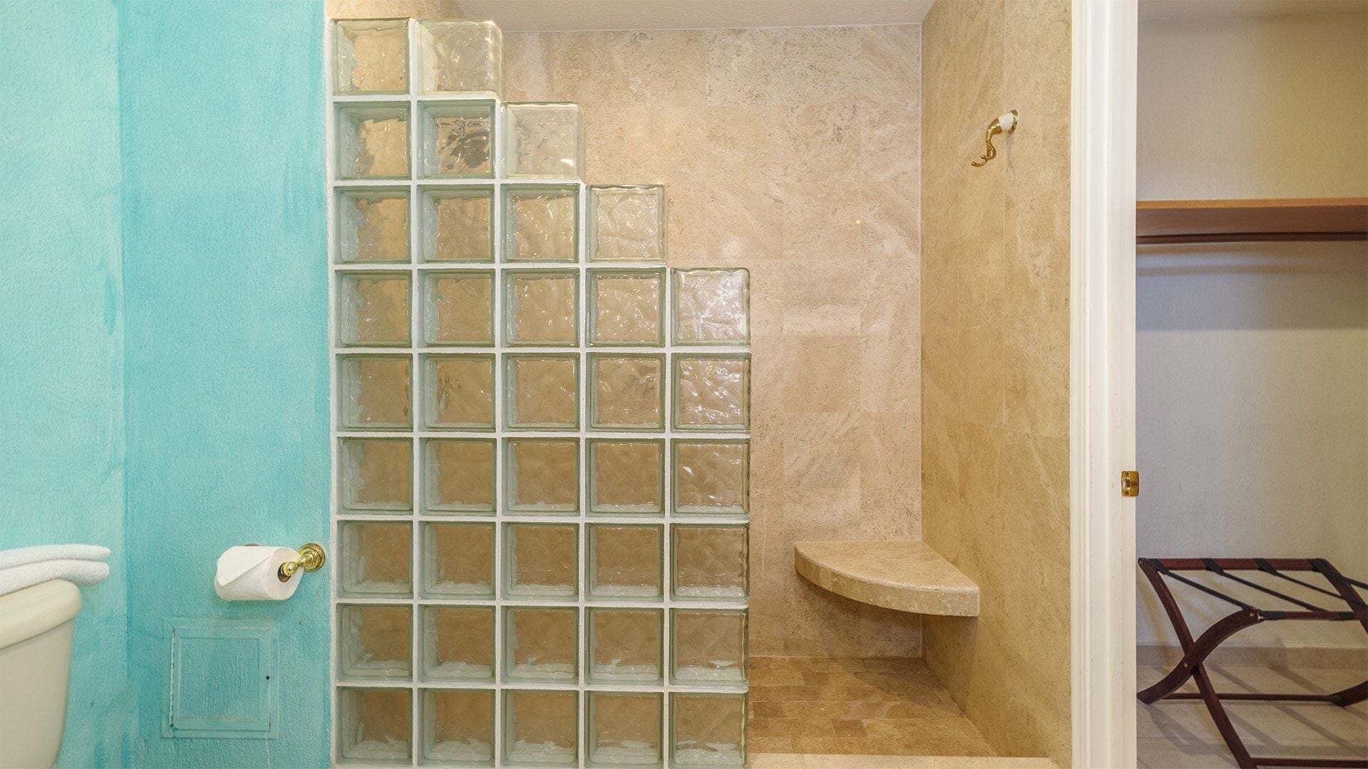 A bathroom with a glass shower enclosure, a toilet, and a sink.