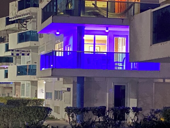 A modern multi-story building with balconies and large windows.