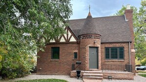 A brick building with a gabled roof, a small porch, and a mailbox. - Modern Tree-Street Retreat/Walkable Location (Casper)
