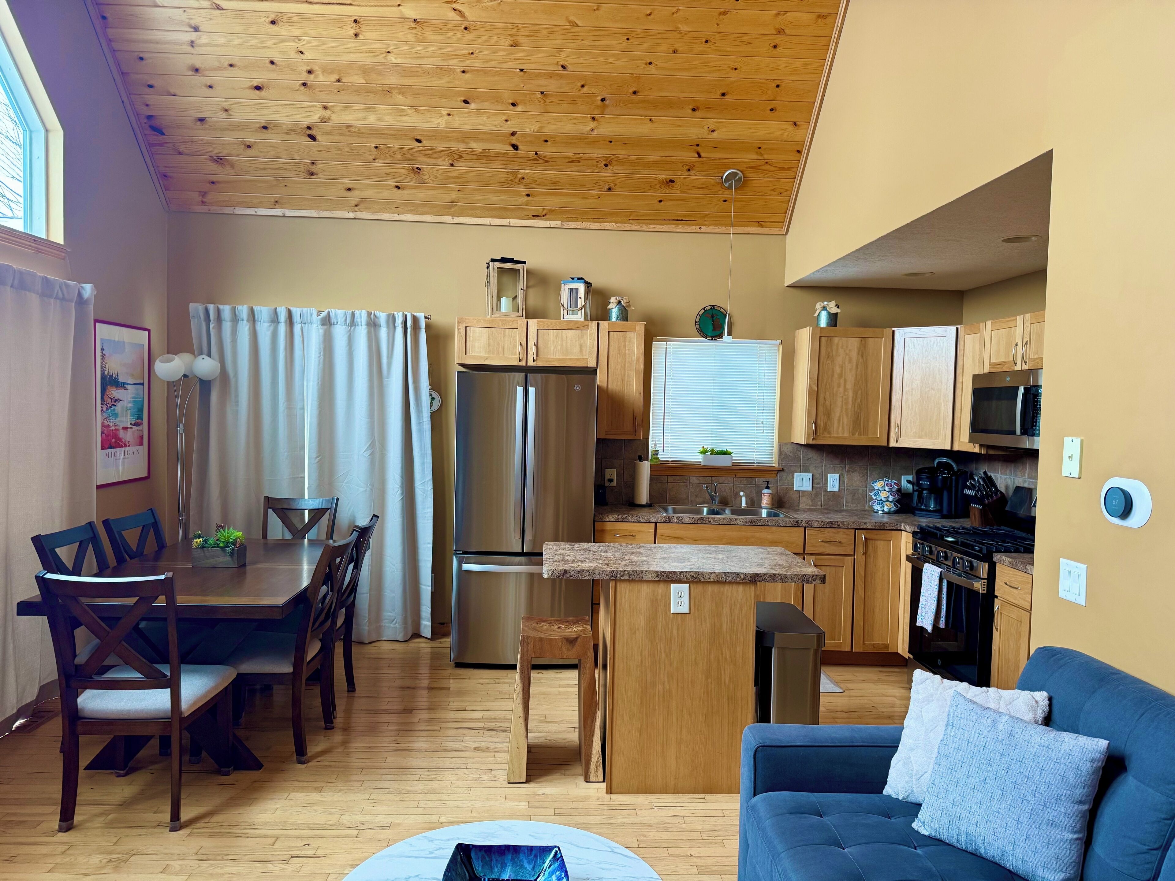 A compact living space with a dining area, kitchenette, and a sofa.