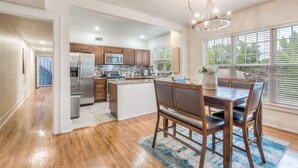 A modern kitchen with wooden cabinets, stainless steel appliances, and a central island. - Carson Flats Apt #4 | 1BR • Near BOK• OSU Med•Dtwn (Tulsa)