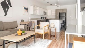 Un appartement moderne comprenant un salon, une cuisine et un coin repas.