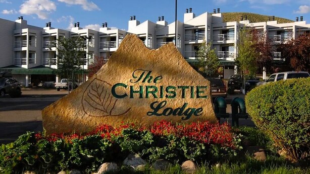 Een bordje van The Christie Lodge, met een berg op de achtergrond.