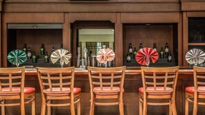 Un espace bar avec des chaises et des tables en bois, chacune agrémentée d’un éventail décoratif.