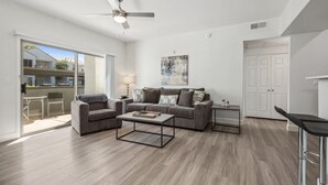 A modern living room with a grey sofa, a coffee table, and a ceiling fan.