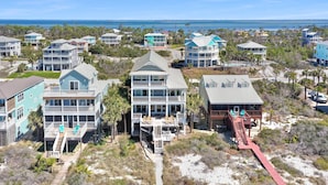A coastal residential area with multi-story houses featuring balconies and decks, connected by a central walkway. - Moonstruck (Port St. Joe)