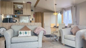A cozy living room with a sofa, two armchairs, and a dining area with a table and chairs. - 2 bedroom accommodation in Ashbourne (Ashbourne)