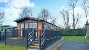 A mobile home with a wooden deck and a staircase leading to the entrance. - 2 bedroom accommodation in Ashbourne (Ashbourne)