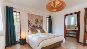 A bedroom with a bed, a nightstand, a wall tapestry, and a large window with curtains. - Kaz Lorizon (Entre-Deux)