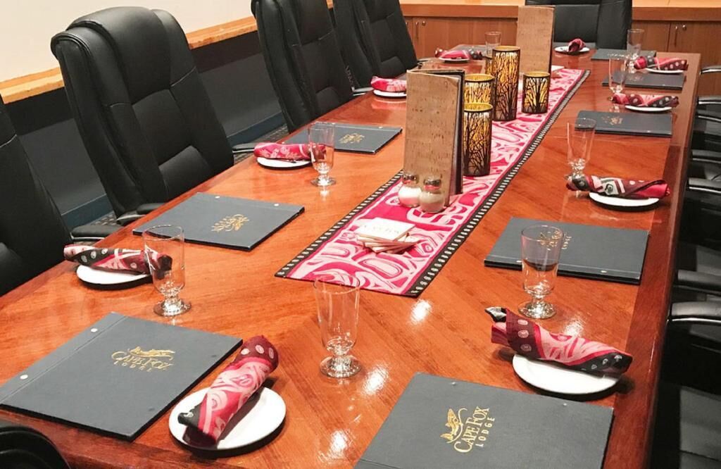 Un salón de conferencias con una larga mesa dispuesta para una reunión.