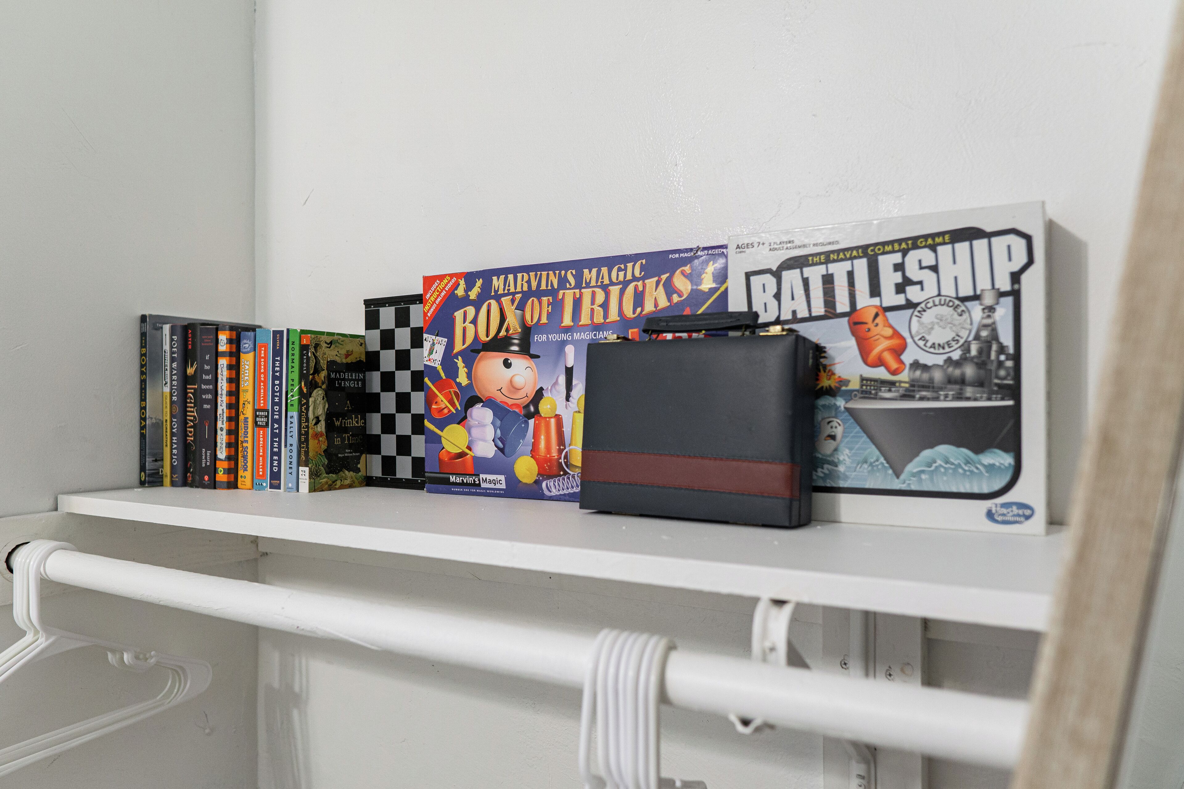 A shelf with books and two game boxes.