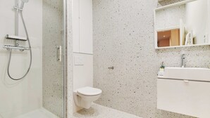 A modern bathroom with a glass-enclosed shower, a white toilet, and a white sink with a mirror above it. - Studio Moderne - 2P- Nanterre (Nanterre)