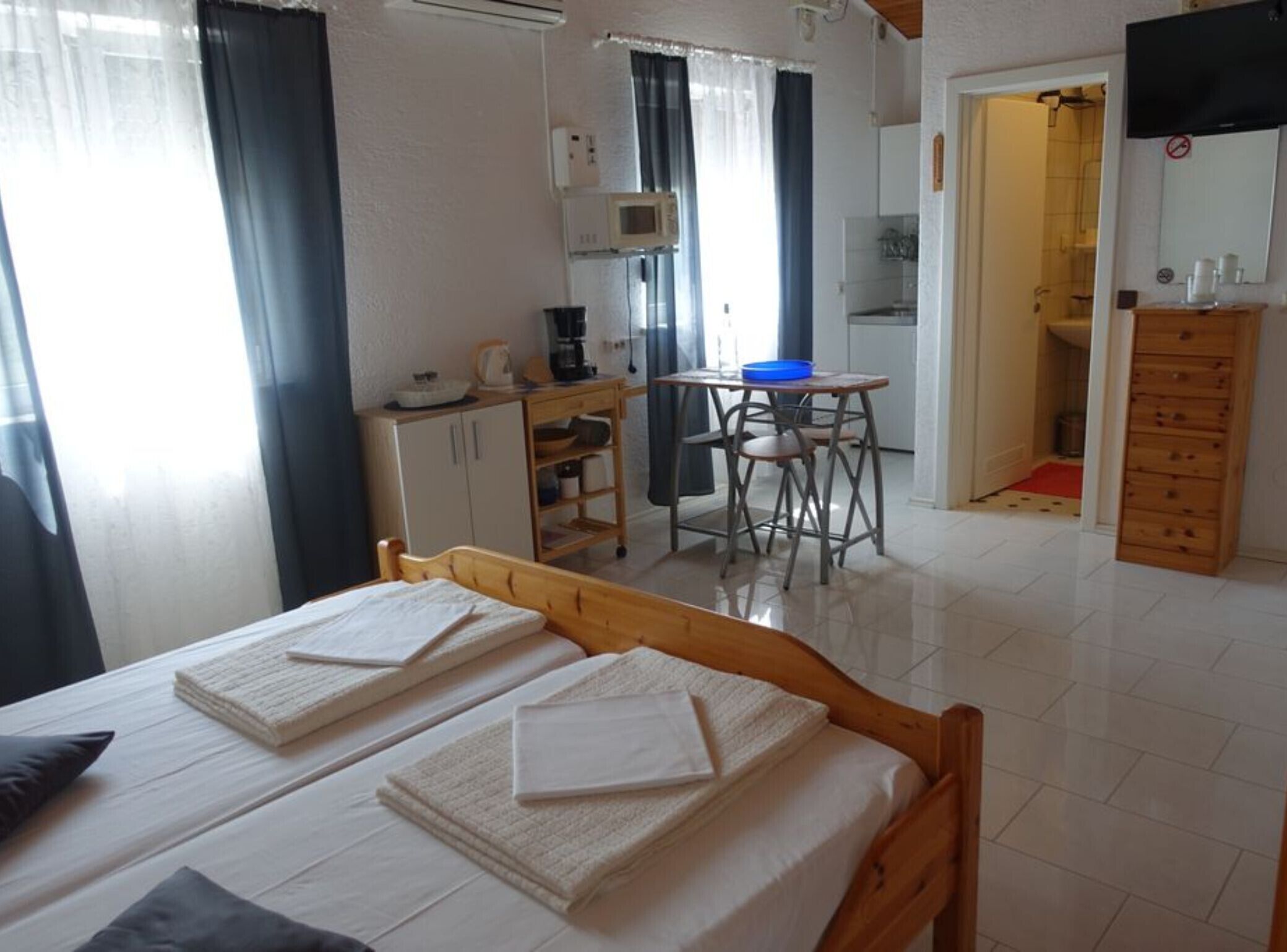 Una habitación con dos camas, kitchenette, comedor y baño.