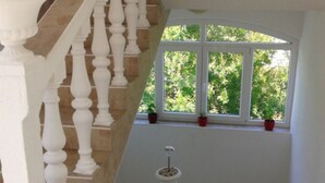 A staircase with white balusters leading to a landing. - Marjetka Charming Apartments - Apartment Daisy (Rab)