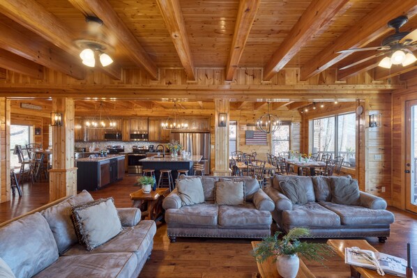 A spacious log cabin interior with a large living area, a kitchen, and dining space. - A View for All Seasons Luxe Smoky Mountain Cabin With Hot Tubs Game Room (Sevierville)