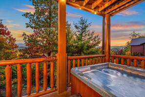 A wooden deck with a hot tub and a view of trees and mountains. - A View for All Seasons Luxe Smoky Mountain Cabin With Hot Tubs Game Room (Sevierville)
