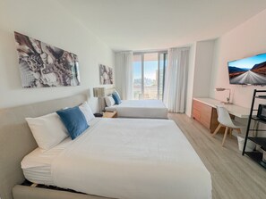 2 habitaciones, escritorio y tabla de planchar con plancha