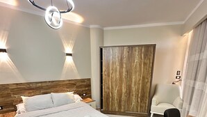 Un dormitorio moderno con una cama grande, cabecera de madera y un armario de madera.