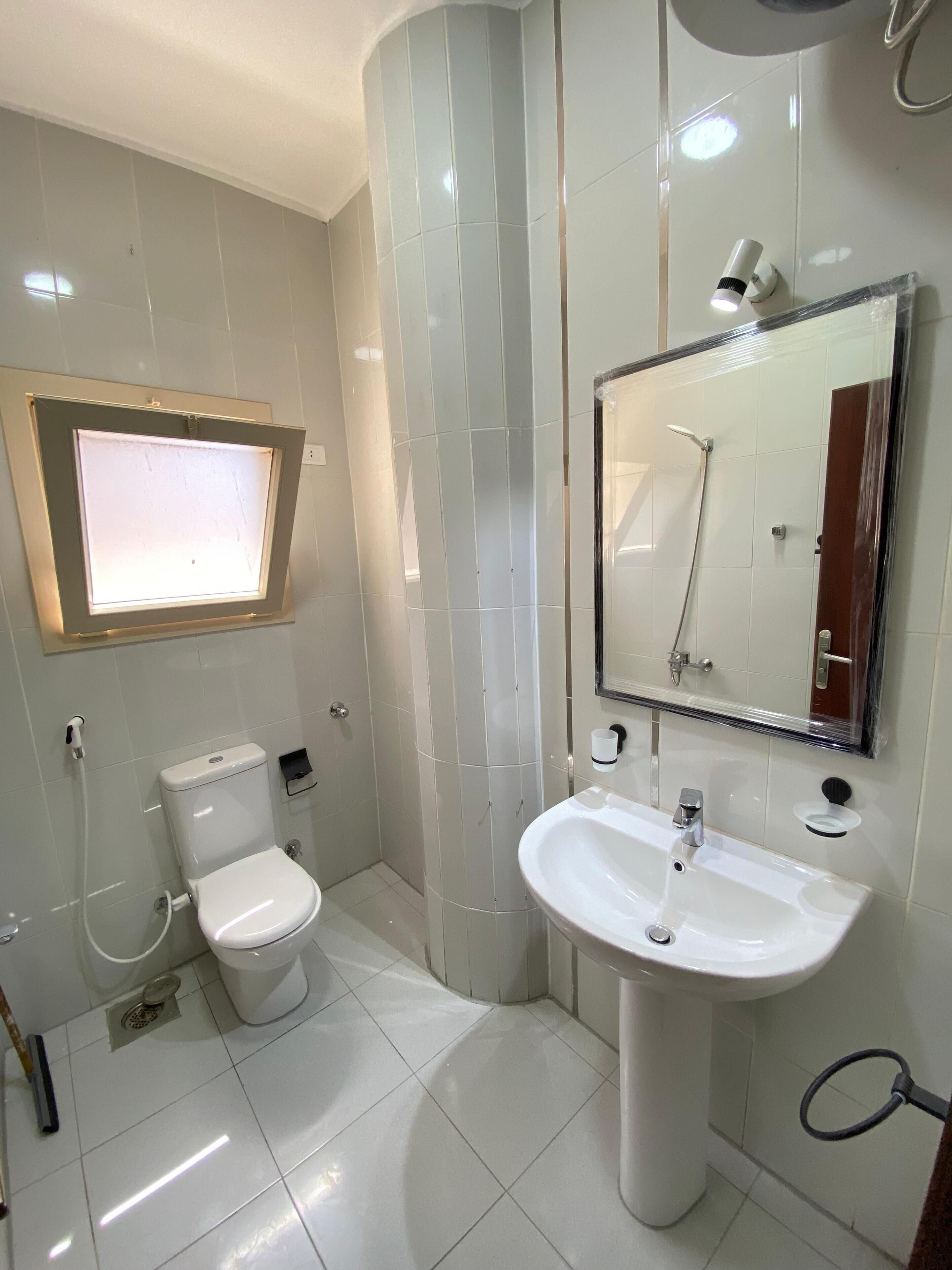 Un bagno moderno con servizi igienici, lavandino e doccia.