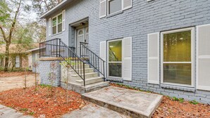A two-story house with a gray brick exterior, white shutters, and a black metal staircase leading to the front door. - Family Retreat w/ Pool Table Near the Woodlands! (Spring)