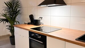 Una cocina moderna con armarios blancos, una estufa negra y una encimera de madera.